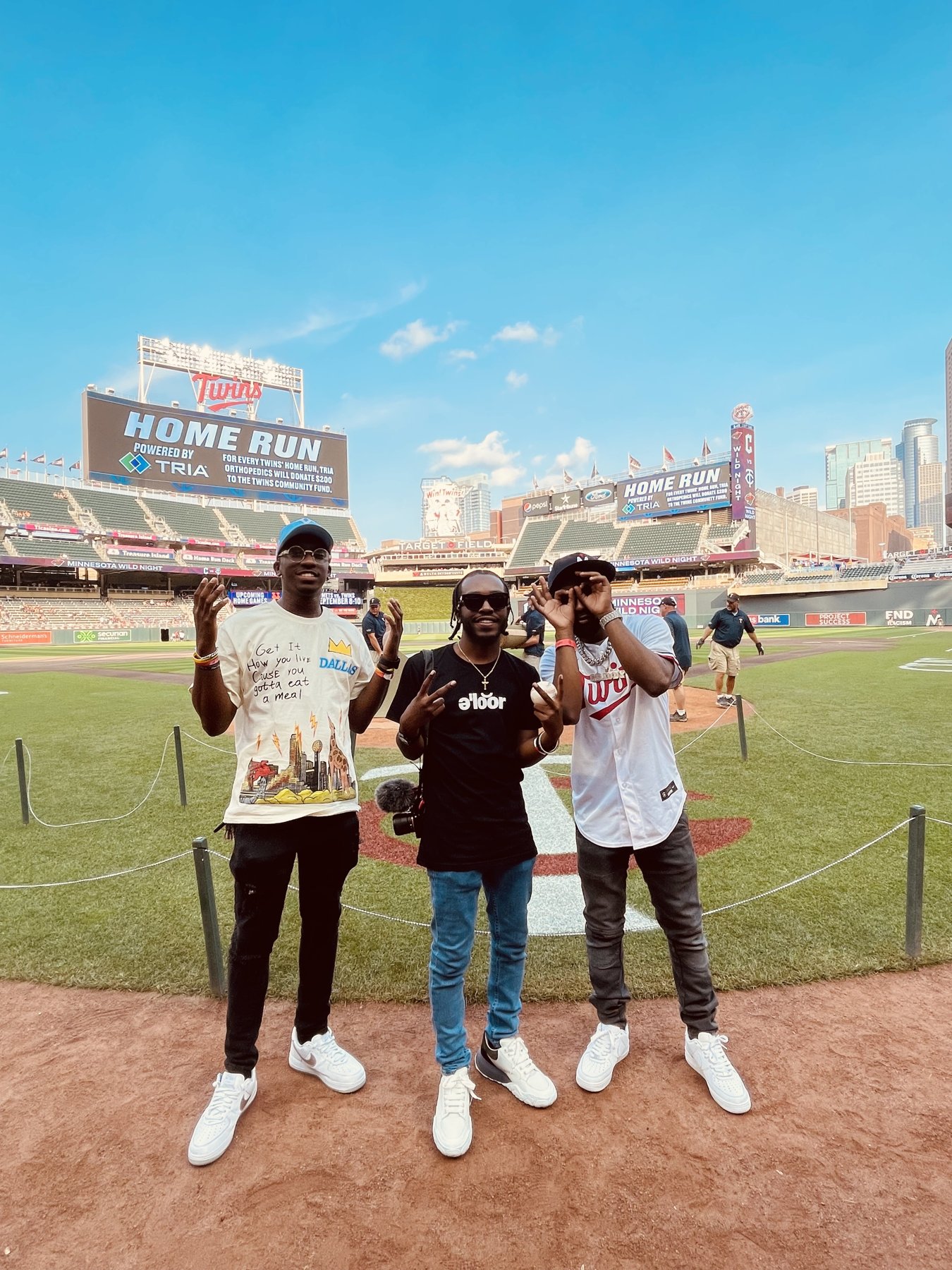 Three friends on a baseball field at a home run event